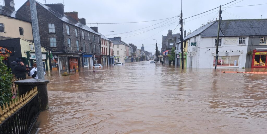 Street completely flooded with houses, businesses and cars partially submerged